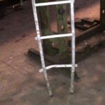 Obrázek ukazuje poškozený žebřík na pracovišti.
